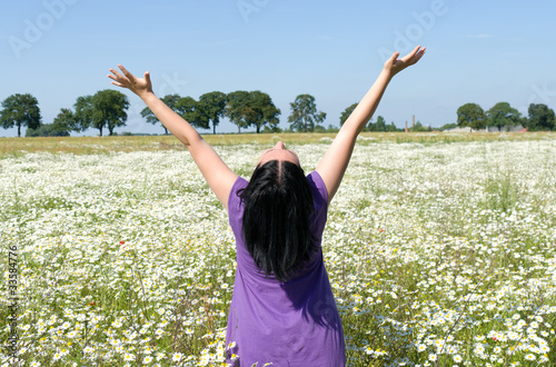 The woman in the flower field with outstretched arms.