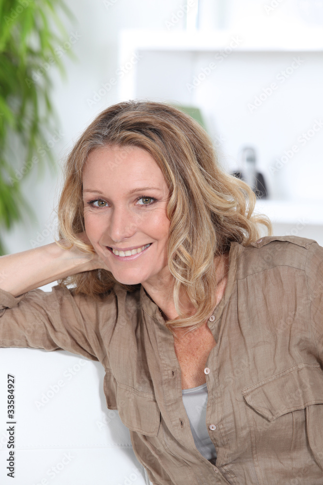 Fototapeta premium Blond female sitting on sofa relaxing