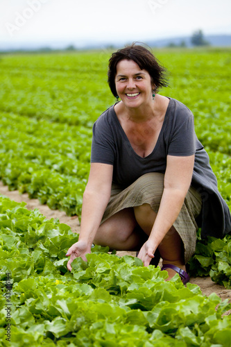 Frau auf Feld mit Kopfsalat
