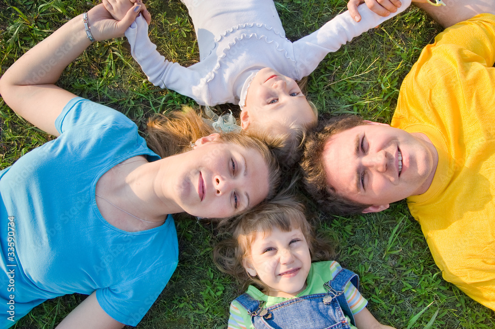 Fototapeta premium Family lying on the grass