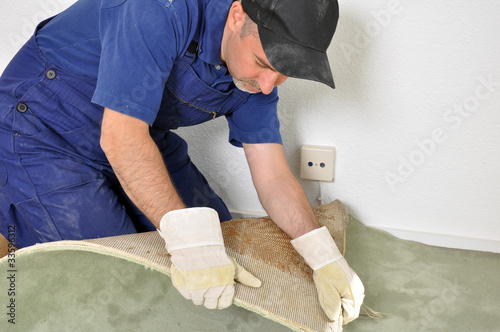 Handwerker beim Entfernen eines Teppichs