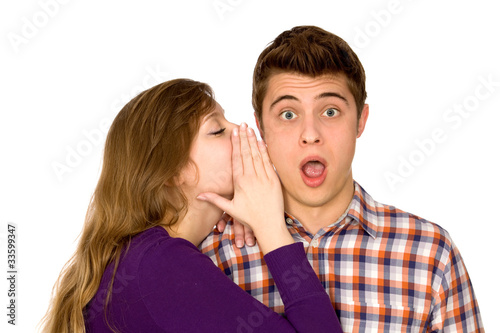 Woman whispering into man's ear