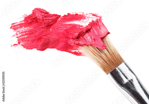 Red lipstick stroke (sample) with makeup brush, isolated on whit