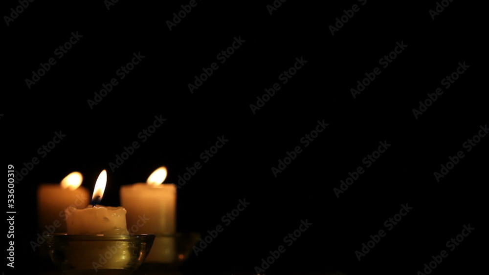 Three candles against the dark background