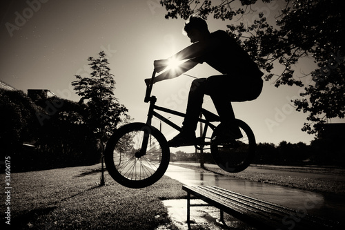 Fotografering boy jumping over bench  on bmx