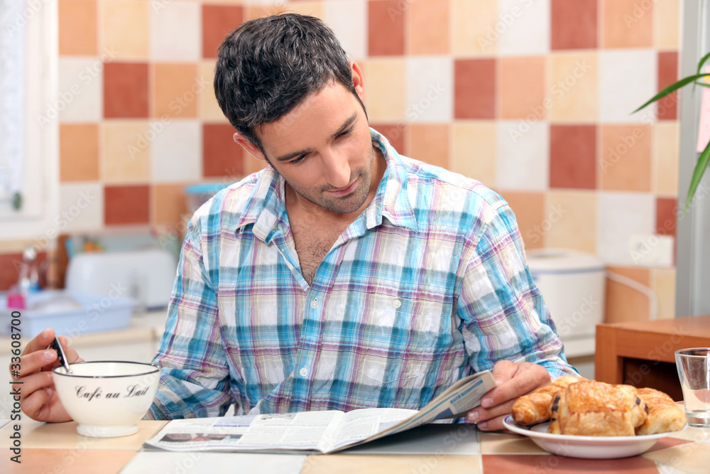 Man reading his newspaper at the breakfast table Man reading his newspaper at the breakfast table