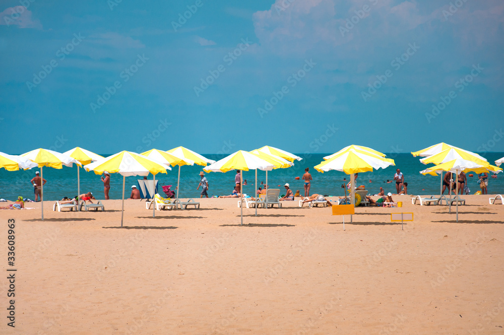 Sandy beach with parasols by the sea