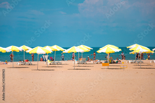 Sandy beach with parasols by the sea