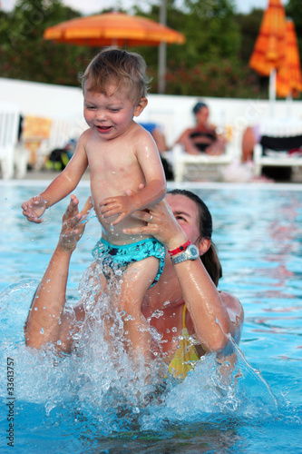 Cute baby playing in the swimmingpool with his mother