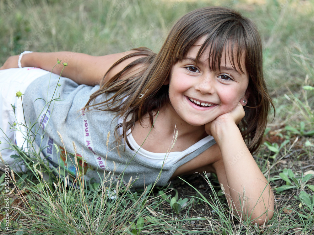 Petite fille allongée dans l'herbe (été 5-6 ans) Stock Photo