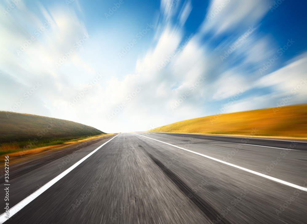 Empty motion blurred asphalt road and blue sky with blurred clouds Empty motion blurred asphalt road and blue sky with blurred clouds