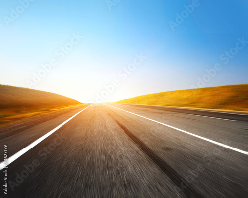Empty motion blurred asphalt road and blue sky with blurred clouds © Dudarev Mikhail