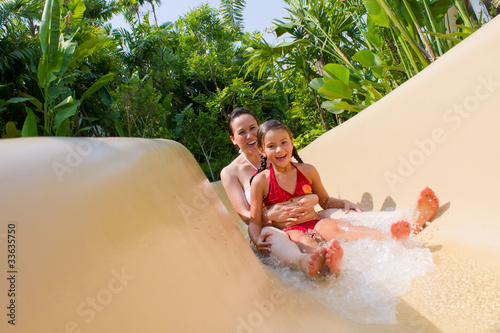 Mother and Daughter Sliding Down Water Slide.