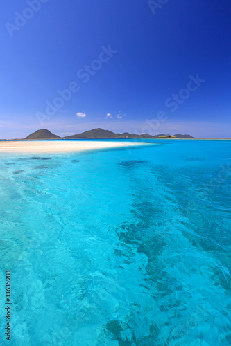 伊平屋島の美しく澄んだ珊瑚礁の海と夏の空