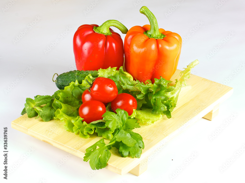 fresh and juicy vegetables on the wood plate isolated