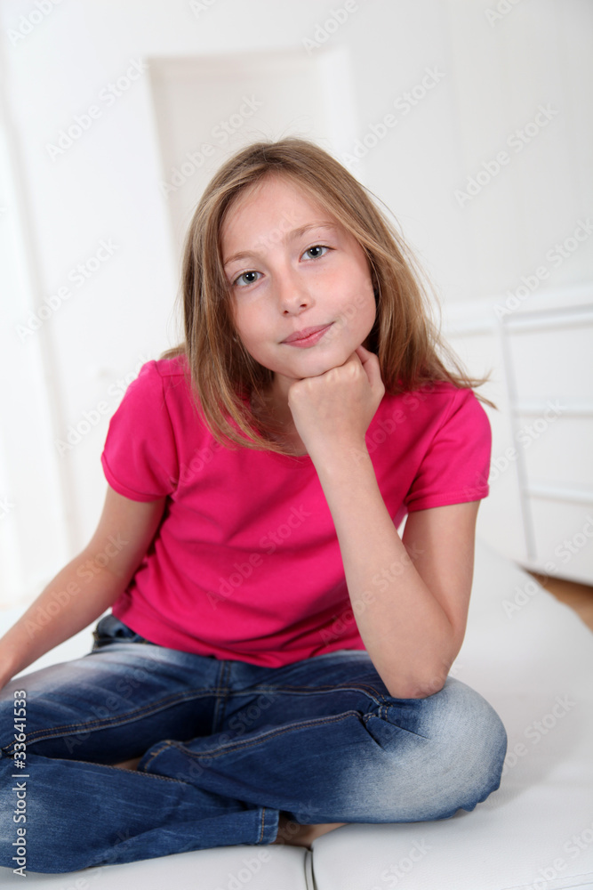 Portrait of blond girl with cross-legged on sofa Portrait of blond girl with cross-legged on sofa