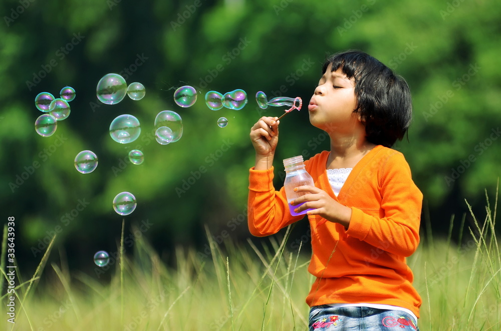 Young Girl playing with soap Bubbles