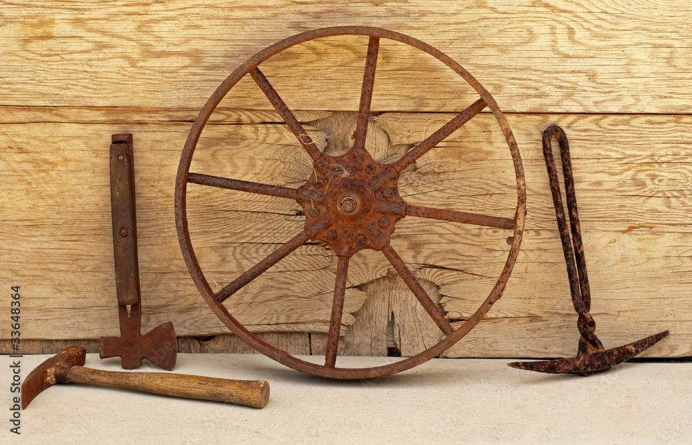 Obraz premium Old iron mining picks, axe & wheel still life