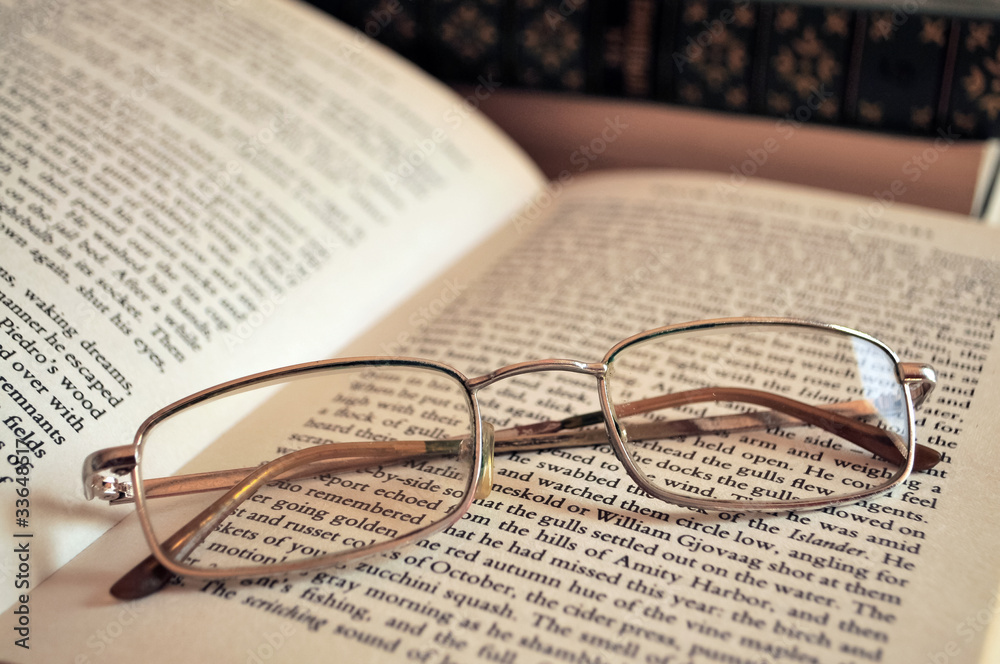 This is a photograph of an eyeglasses lying on open book This is a photograph of an eyeglasses lying on open book