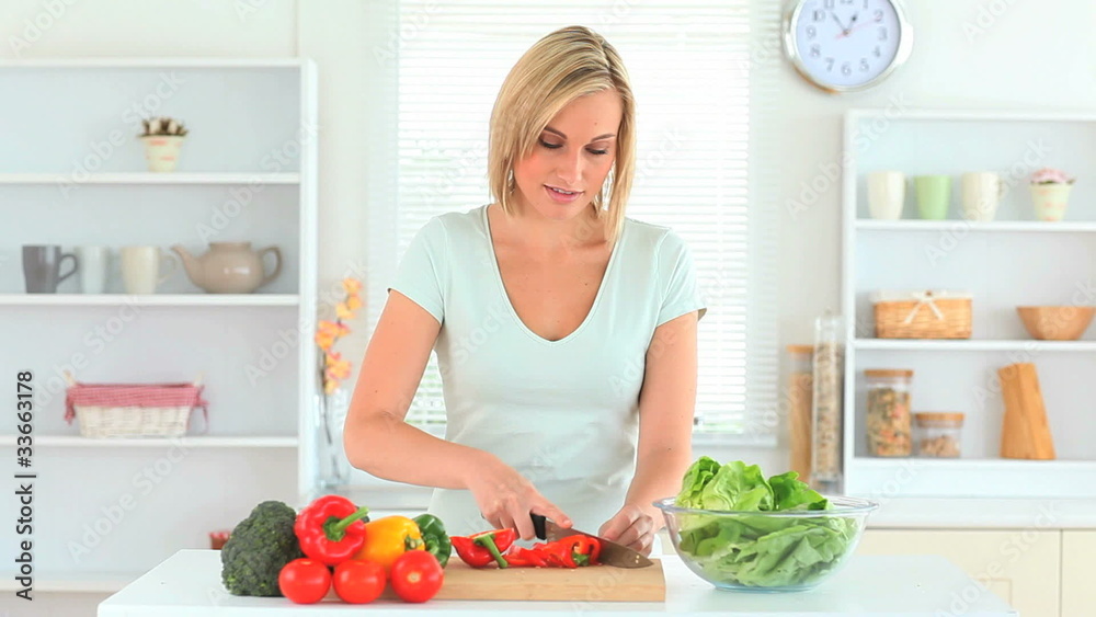 Blond-haired woman slicing peppers Blond-haired woman slicing peppers