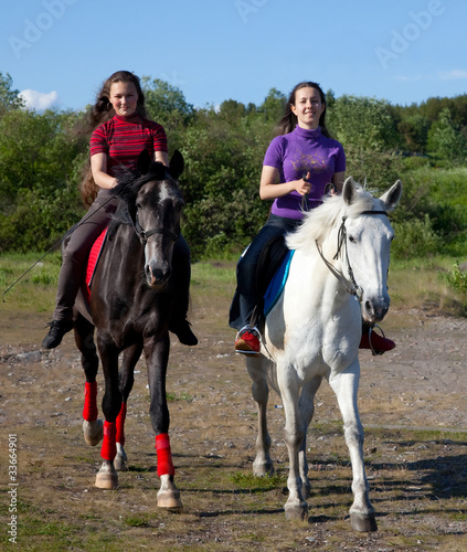 Two girls walking on horseback