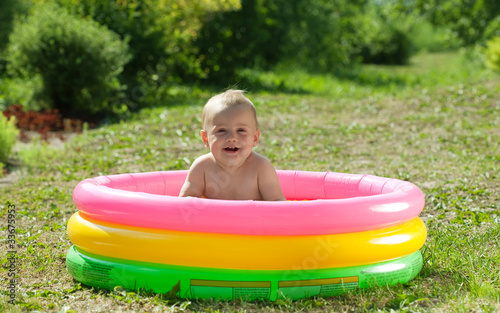 Happy baby swimming  in   pool photo