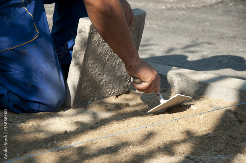 Worker puts sidewalk tiles