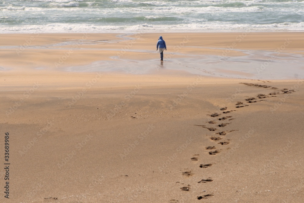 Fußspuren im Sand und Person am Sandstrand in Island Fußspuren im Sand und Person am Sandstrand in Island