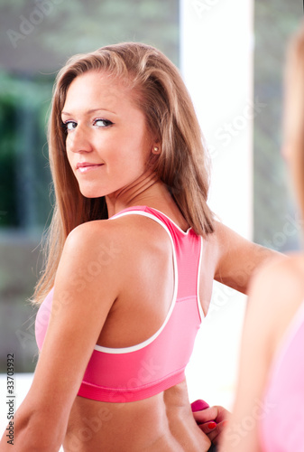 Young woman making exercise in gym with dumbbell