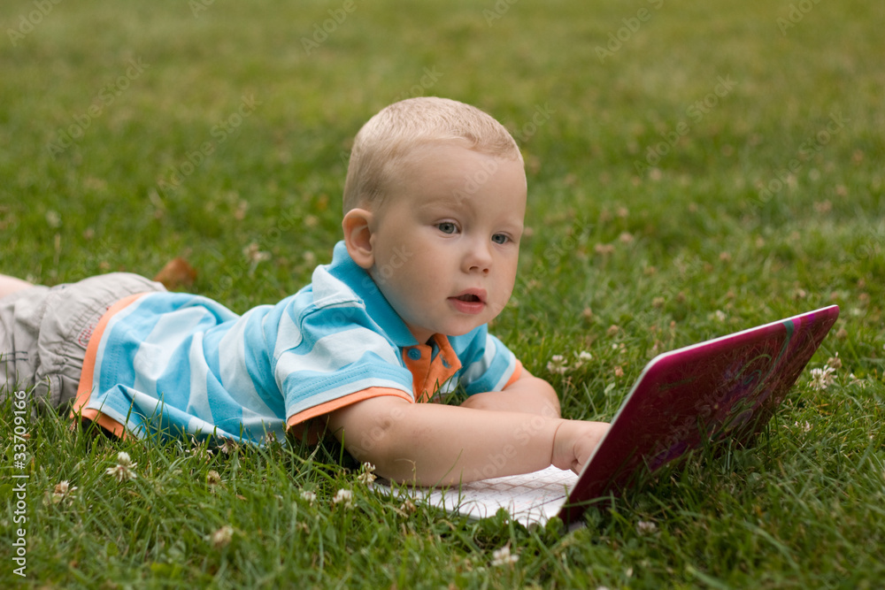 Child with notebook on the grass Child with notebook on the grass