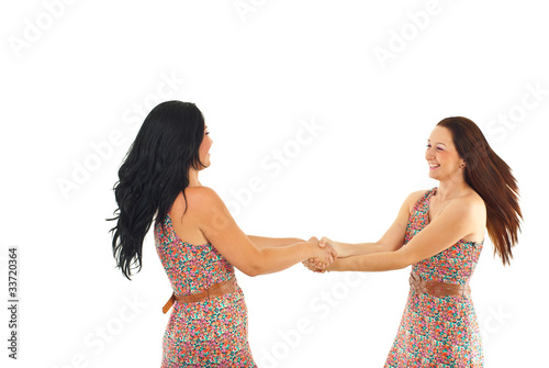 Two women twirl together