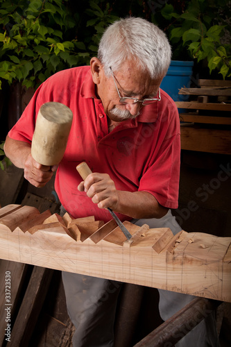 Photo woodcarver working with mallet and chisel