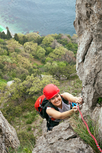 Female climber ascending a rock