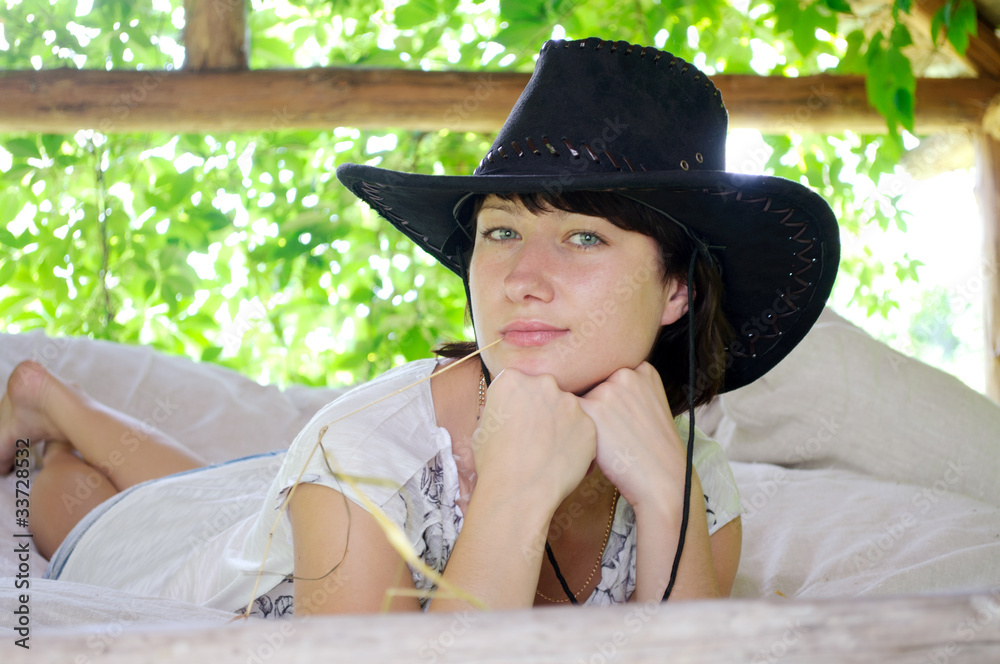 beautiful girl in the hat lying in the open air