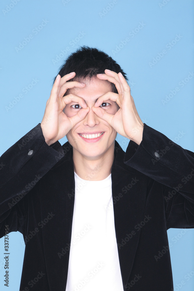 指で眼鏡を模る男性 指で眼鏡を模る男性