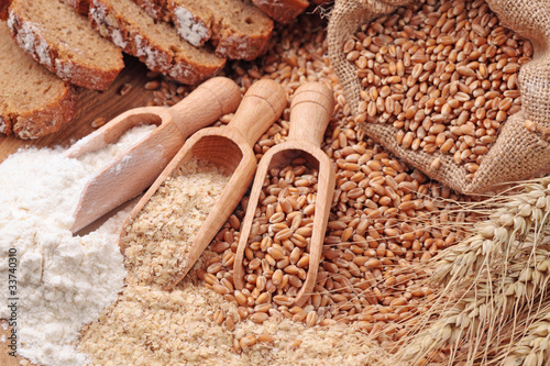 Photo Wood spoons with whole wheat grains, wheat bran and flour