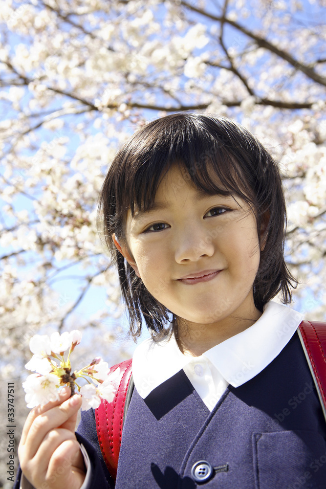 桜の花を持つ小学生女子