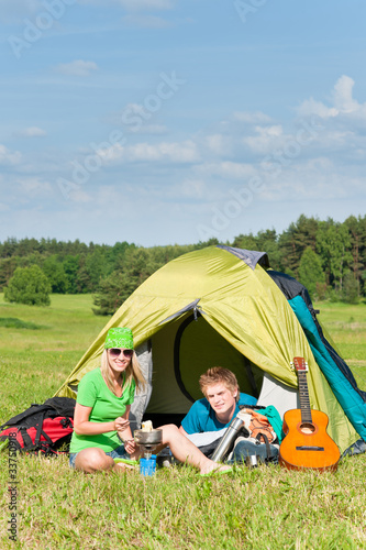 Young camping couple cooking meal outside tent © CandyBox Images