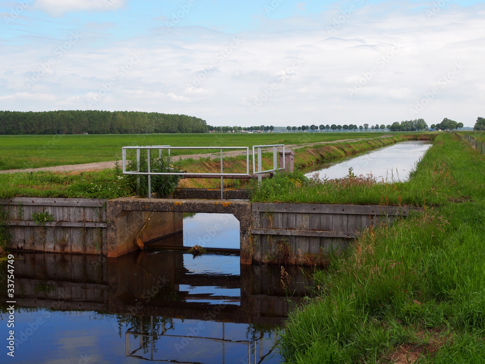 a weir in typical dutch agricultural landscape