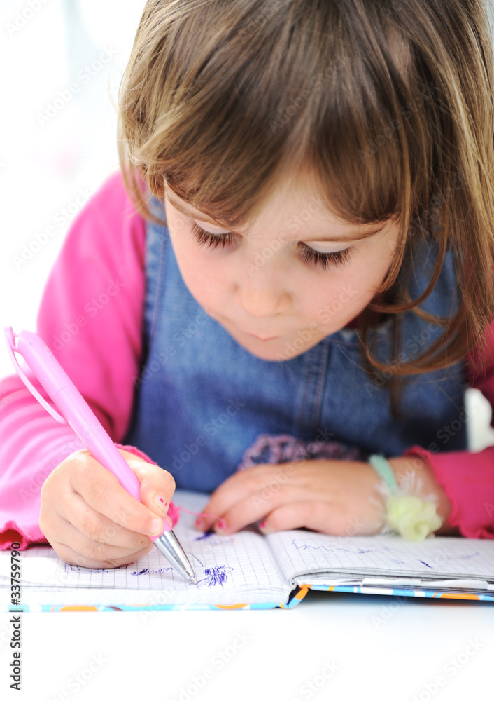 Happy little girl drawing with pencils at home Happy little girl drawing with pencils at home