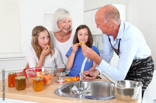 Grandparents cooking with kids in home kitchen
