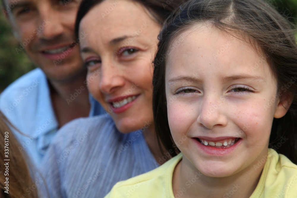 Portrait of smiling little girl with parents in background Portrait of smiling little girl with parents in background