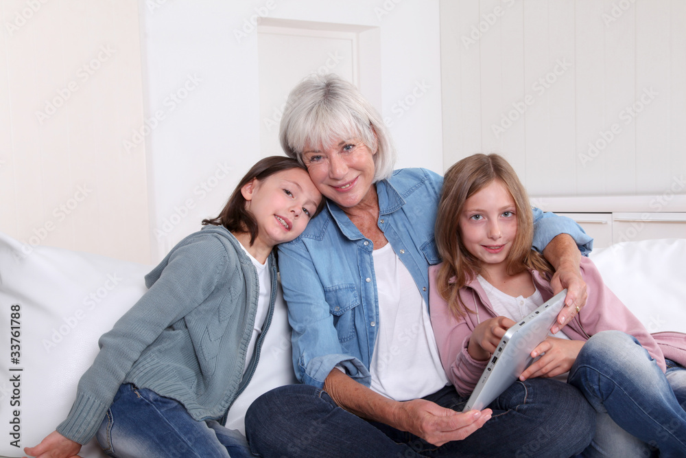 Senior woman with grandkids playing with touchpad