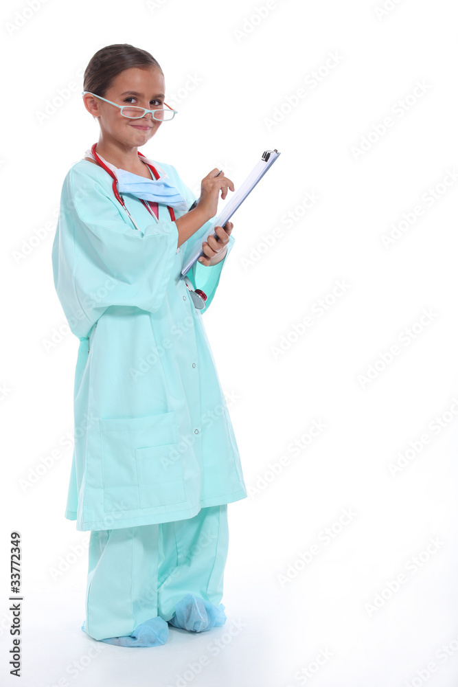 Child in a doctors scrubs with stethoscope and clipboard Child in a doctors scrubs with stethoscope and clipboard