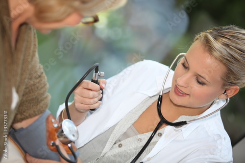 Doctor measuring the blood pressure of a patient photo