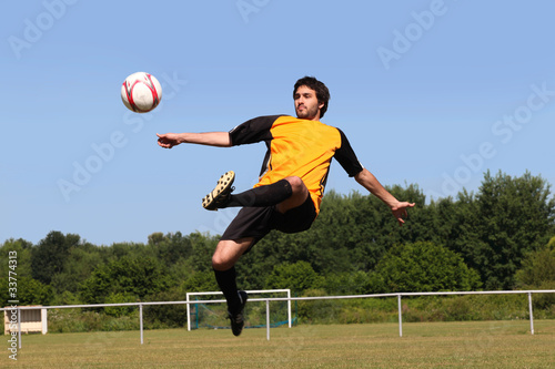 Footballer kicking the ball in mid air
