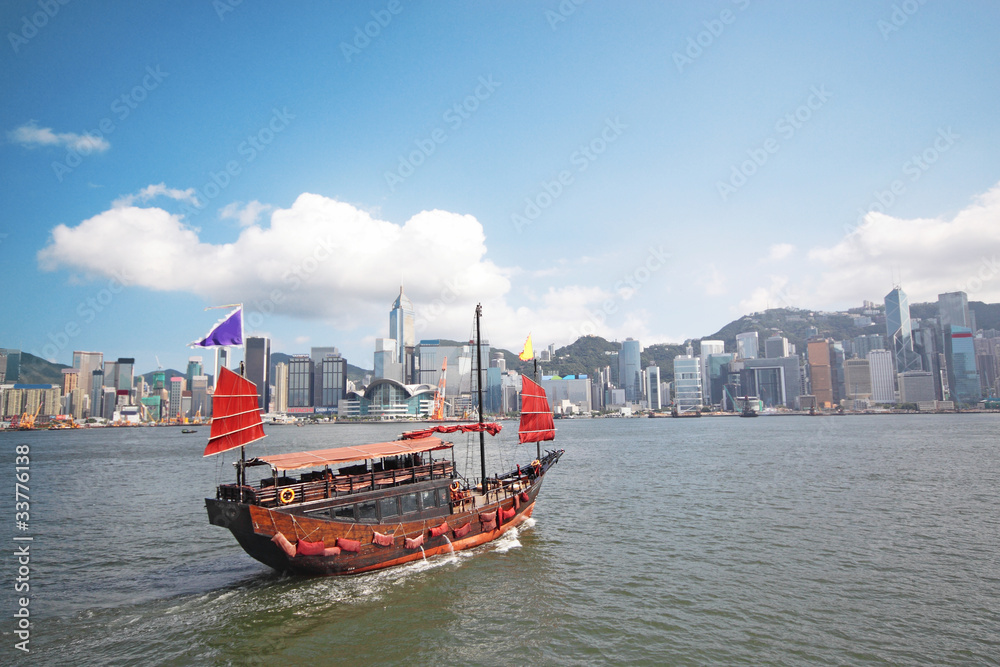 Obraz premium Junk boat with tourists in Hong Kong Victoria Harbour