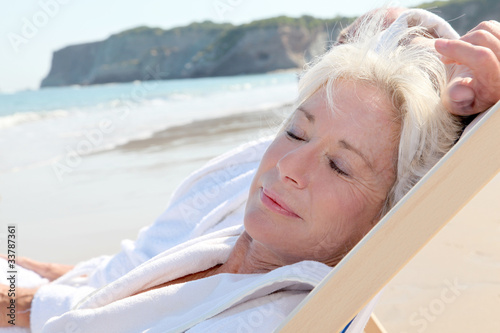 Portrait of senior woman relaxing in longchair photo