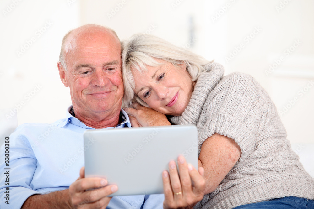 Senior couple using electronic tablet at home Senior couple using electronic tablet at home