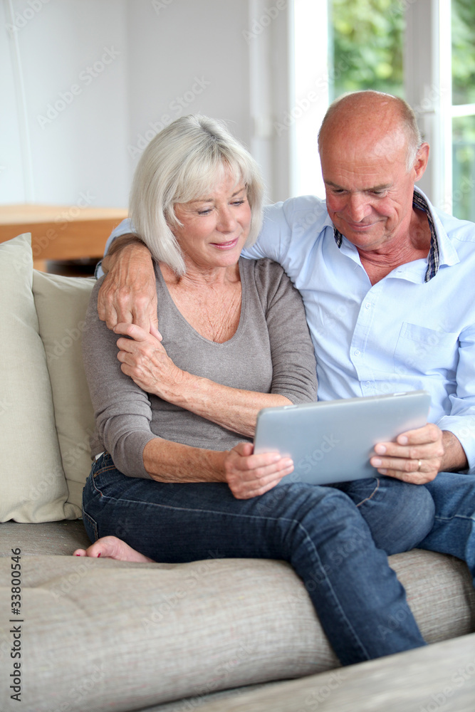 Senior couple using electronic tablet at home Senior couple using electronic tablet at home
